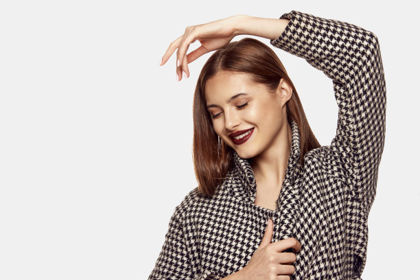 年轻美丽的女孩摆造型的时尚夹克孤立在白色背景的肖像。深红色的唇妆look。美、时尚和美容的概念图片下载