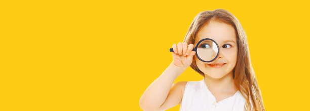 孩子的肖像通过放大镜看孤立在黄色背景图片下载