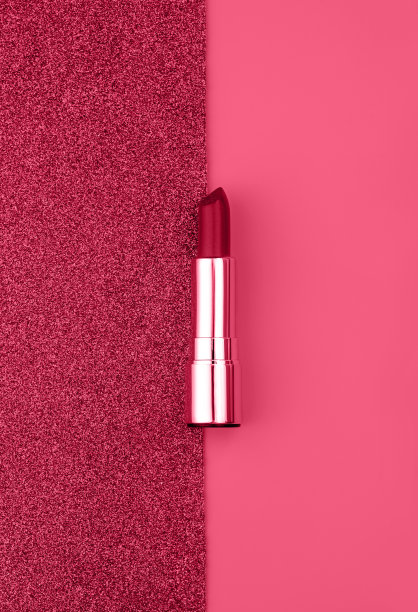 平面构图与口红明亮闪闪发光的背景。调色图像在时尚品红色的2023年。图片下载