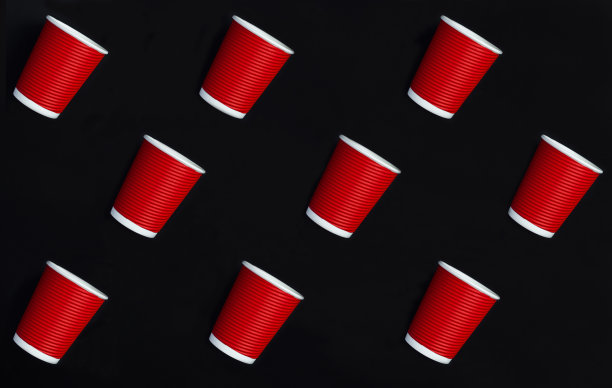 俯视图一次性红纸杯在黑色背景。模式。平的。图片下载