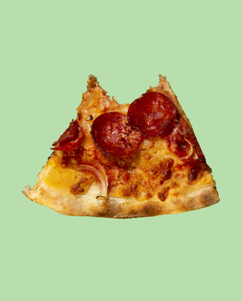 一片咬过的意大利辣香肠披萨，背景是意大利腊肠。图片下载
