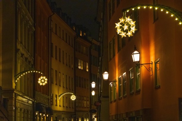 瑞典斯德哥尔摩老城区的街道(Gamla Stan)在圣诞节的夜晚被节日般的装饰图片下载
