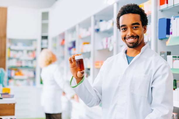 快乐的非裔美国药剂师拿着一瓶药。图片下载