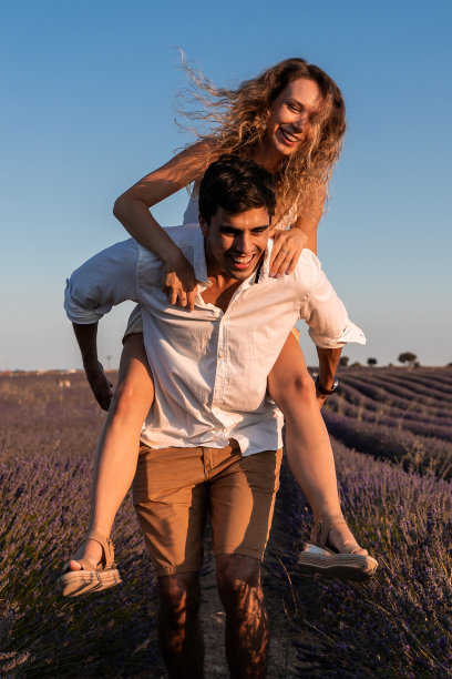 一对情侣在薰衣草地里嬉戏的垂直照片图片下载
