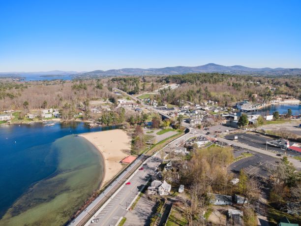 在清澈的蓝天下，湖边的道路上有汽车和建筑物图片下载