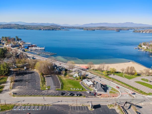 在清澈的蓝天下，湖边的道路上有汽车和建筑物图片下载