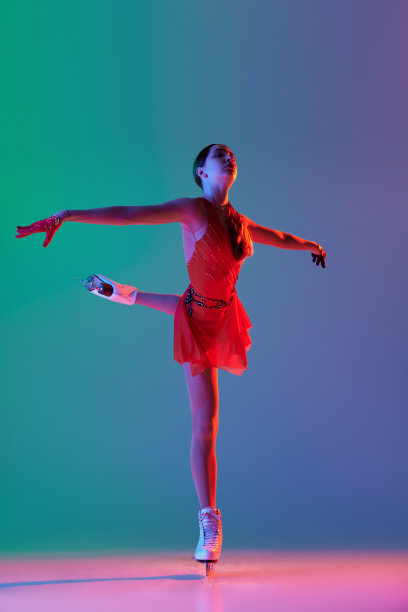 年轻活泼的女孩，年轻的女子花样滑冰运动员在红色舞台服装滑冰孤立在渐变蓝绿色背景的霓虹灯。优雅，美丽，冬季运动图片下载