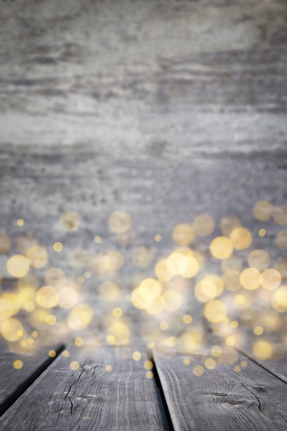 木材表面和散焦散焦金色灯光在背景。图片下载
