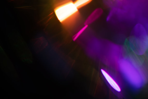 模糊的光画在相机曝光。光线在黑暗的背景上以光谱梯度闪耀。图片下载