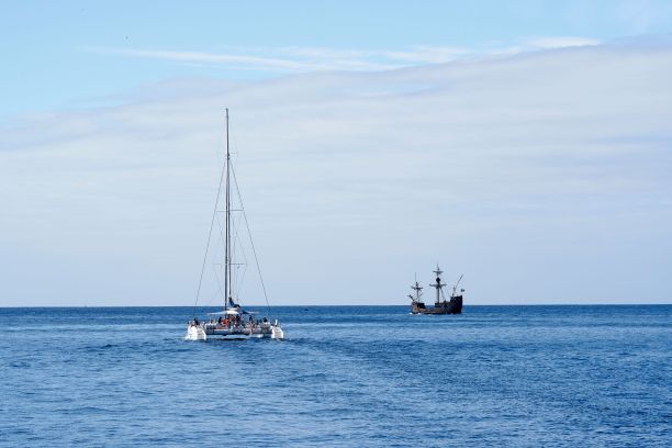 双体船和海盗船在广阔的海洋相遇图片下载