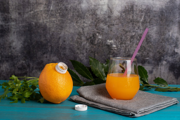 一杯橙汁，旁边放一个开口的橙子，这是橙汁的来源。特写镜头。图片下载