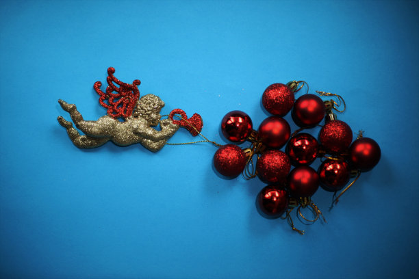 新年的装饰品是长着红翅膀的金色天使和红色的装饰物图片下载