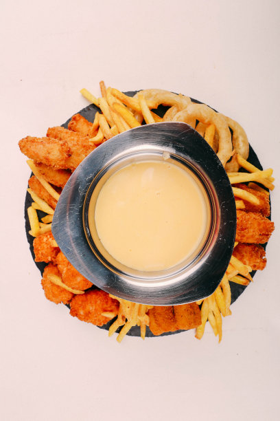 美味的小吃盘，炸薯条，洋葱圈，春卷或香肠放在桌子上图片下载