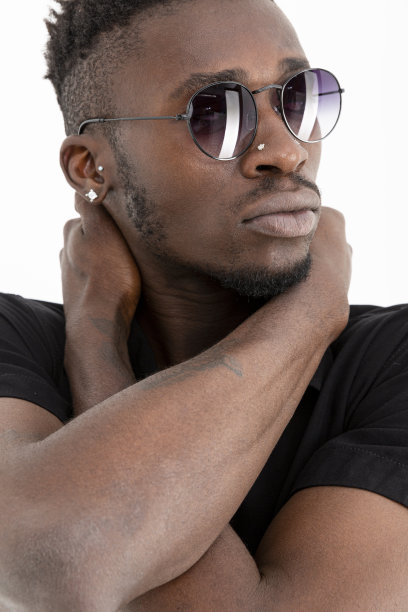 一个非洲裔美国人，穿着黑色衬衫，戴着太阳镜，背景是白色的。图片下载