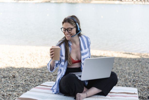 一个年轻女子的肖像自由职业者和享受河边图片下载