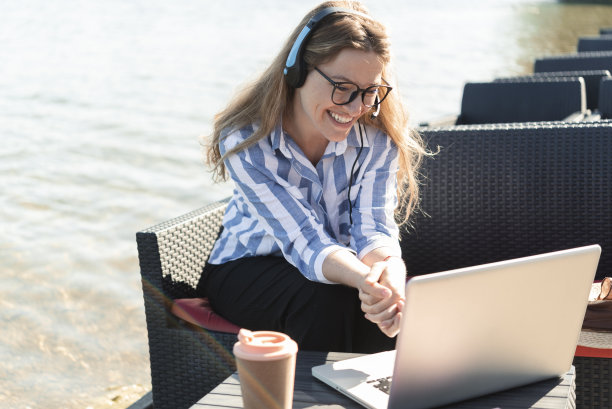 一个美丽的自由职业者的肖像从河边的咖啡馆工作图片下载