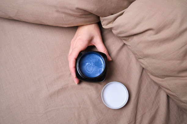 女人的手和一罐身体霜的特写在自然的背景。水疗身体护理。本空间图片下载