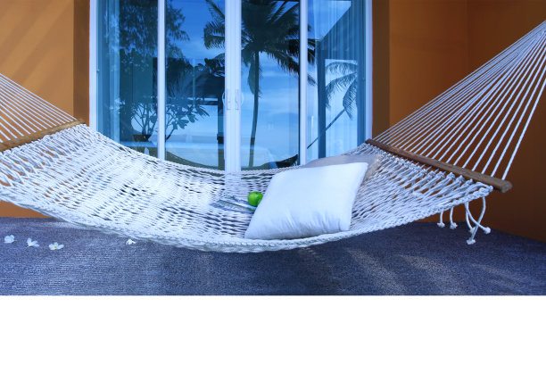 吊床放在沙滩边一座橘黄色房子前抛光的石头地板上图片下载