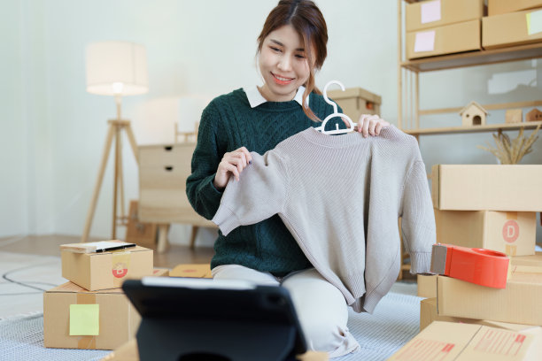 一个独立的年轻亚洲女性在线卖家用平板电脑向客户展示产品，然后再做出购买决定。中小企业交付概念图片下载