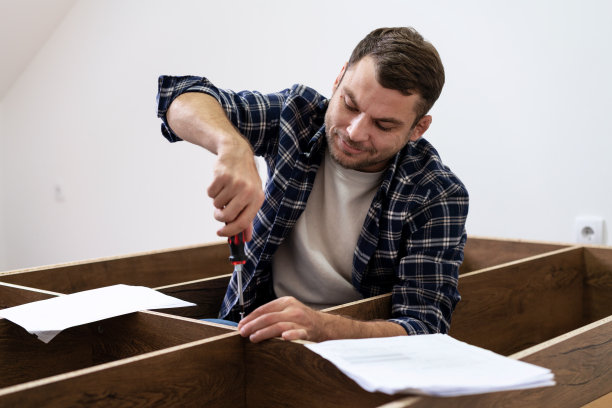 工人使用说明书和螺丝刀组装新衣柜。图片下载