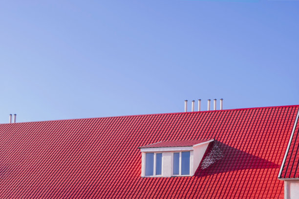 现代红色屋顶的金属瓦在蓝色的天空背景图片下载