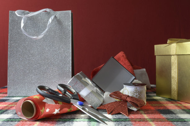 礼品盒、剪刀、包装纸、漂亮的圣诞礼物袋子放在桌子上。等。图片下载