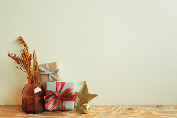 礼品盒，干花花瓶，木桌上的圣诞装饰品。象牙墙背景。冬季圣诞，复制空间图片下载