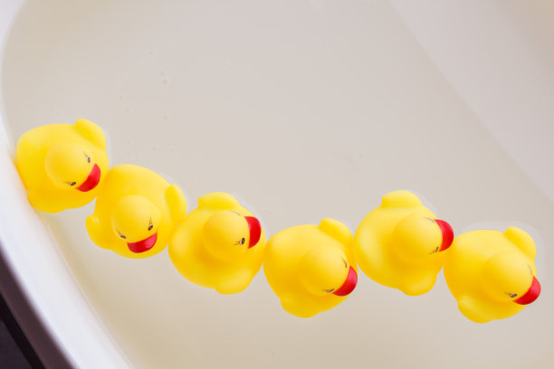 橡皮鸭一只接一只地在水里游泳。图片下载