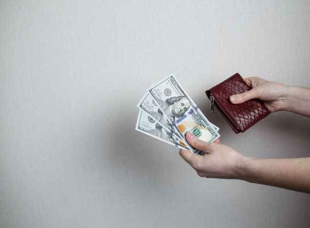 女孩拿着钱和钱包。图片下载