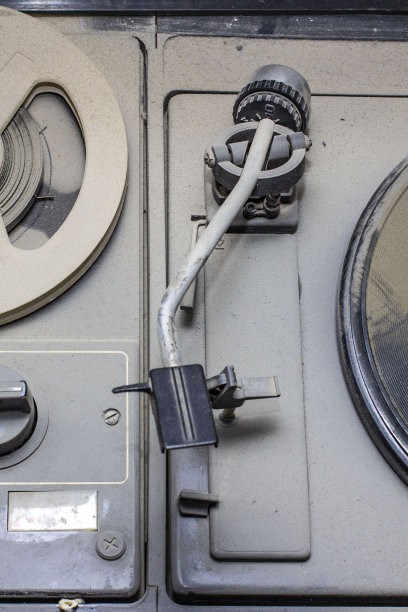 一台老式的盘式磁带录音机和留声机被厚厚的一层灰尘覆盖，前后背景模糊，有散景效果图片下载