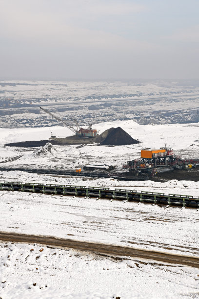 冬季条件下露天煤矿上的大型挖掘机。雪下采矿的有趣外观。图片下载