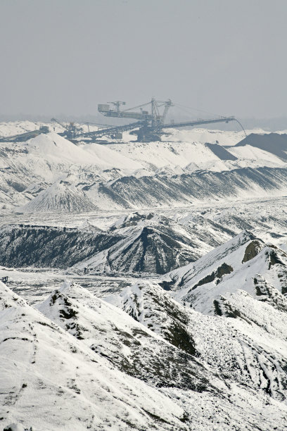 冬季条件下露天煤矿上的大型挖掘机。雪下采矿的有趣外观。图片下载
