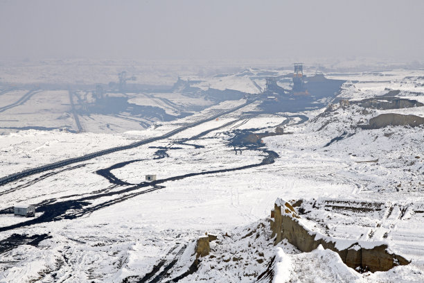冬季条件下露天煤矿上的大型挖掘机。雪下采矿的有趣外观。图片下载