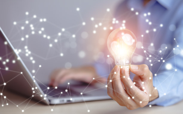 商人手握标有图标的灯泡，在桌子上工作，创造力和创新是成功的关键。新理念和创新理念与能源和动力，在家工作，图片下载