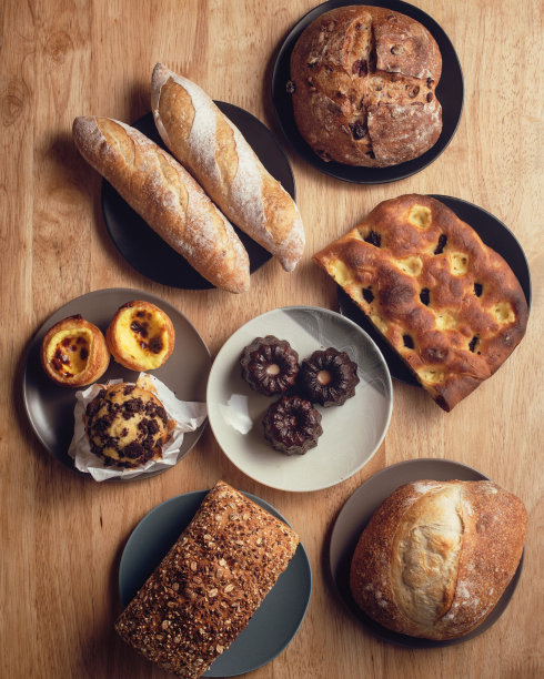 各式各样的面包放在木制背景上。图片下载