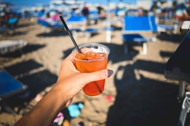 女人拿着一杯橙汁鸡尾酒和一片橙汁。图片下载