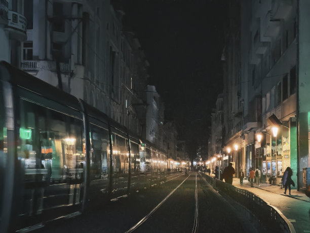 卡萨布兰卡有轨电车在夜晚经过，被城市的路灯照亮图片下载
