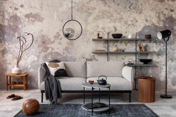 阁楼风格的现代公寓，灰色沙发与格纹，地毯，咖啡桌，和个人配件。灰色混凝土墙。家居装饰。模板图片下载