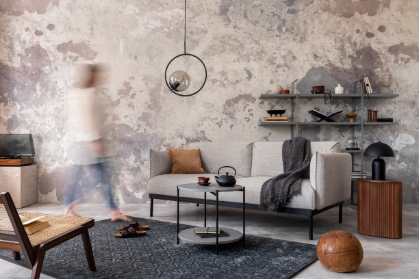 阁楼风格的现代公寓，灰色设计的沙发，扶手椅，梯子，黑色咖啡桌，黑色梯子，迂腐的灯，地毯，装饰和优雅的配件。混凝土垃圾墙。模板。图片下载