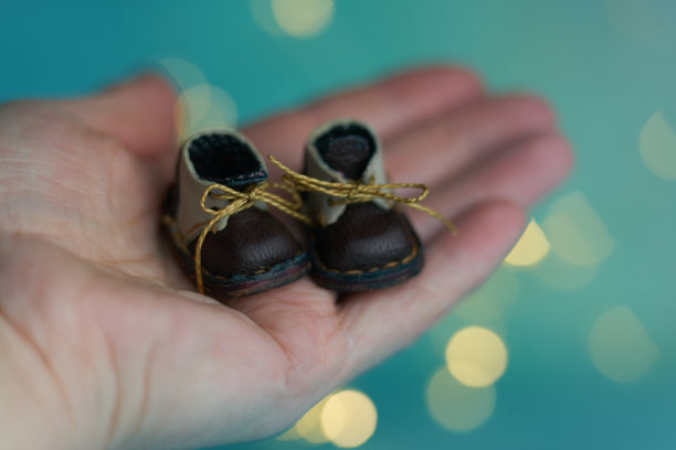 可爱的小靴子的泰迪熊或玩偶在圣诞光的背景。节日光辉的背景。背景与闪烁的光散焦。模糊的散景。图片下载