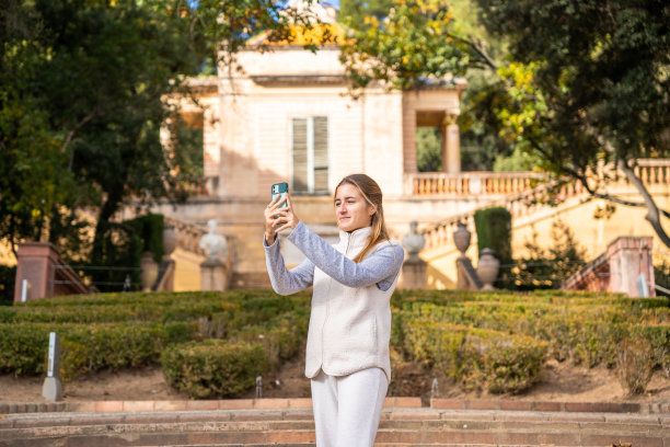 一个女孩用她的手机拍照。图片下载
