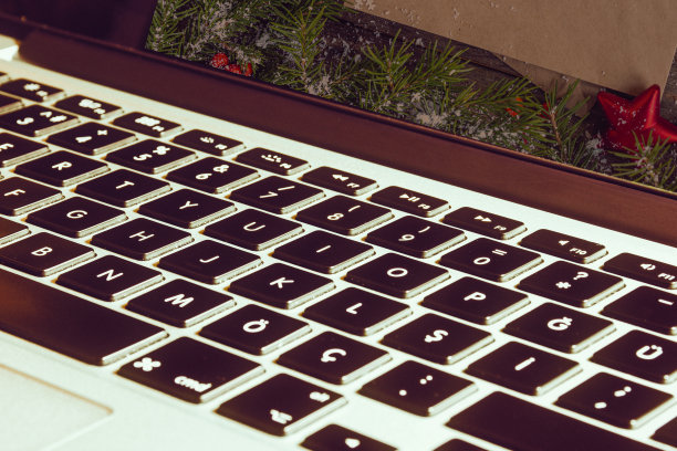 特写视图的笔记本电脑屏幕与圣诞贺卡。欢乐的圣诞场景与电脑显示。准备寄圣诞卡。科技希腊圣诞卡图片下载