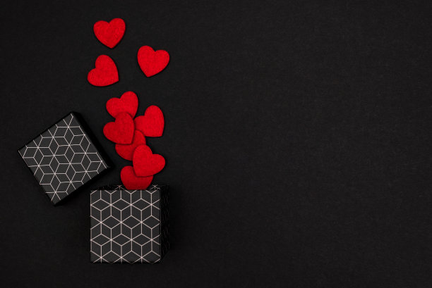 有几何图案的礼品盒。黑色背景的礼品盒里有爱心，上面有铭文图片下载