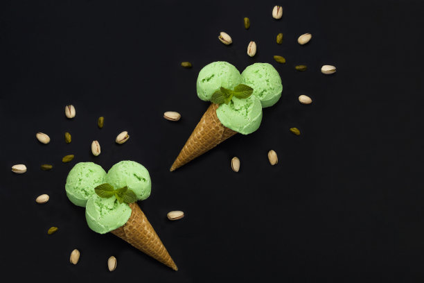 开心果冰淇淋在华夫蛋筒上的黑色背景。副本的空间。前视图。图片下载