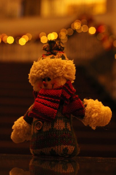 专注于雪人装饰。背景中模糊的灯光和楼梯图片下载