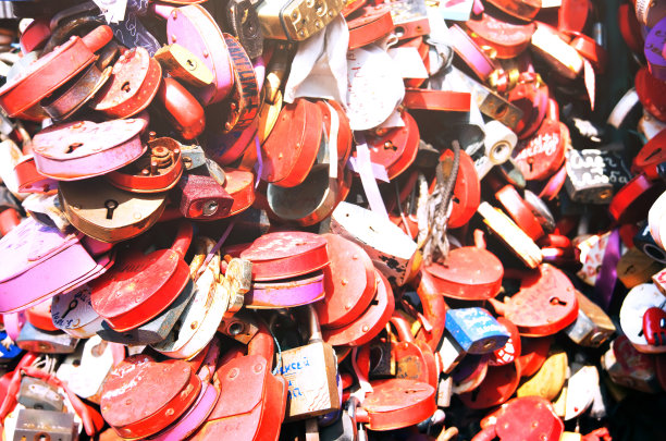 红色的心形锁挂在栏杆上。特写镜头图片下载