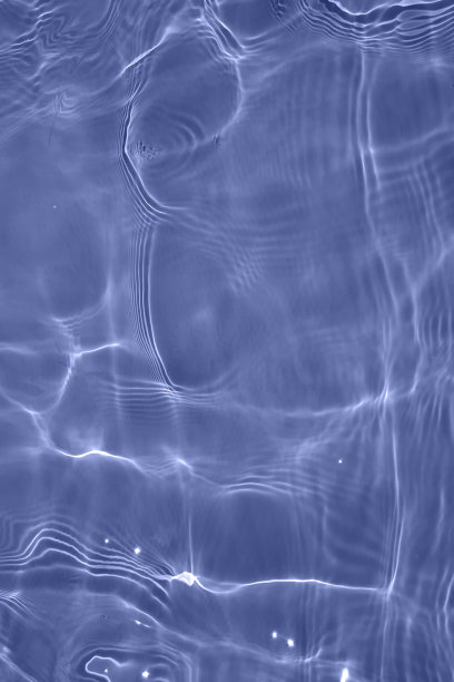 离焦模糊透明蓝色颜色清晰平静的水面纹理与飞溅和气泡。潮流抽象的自然背景。水波在阳光下带有焦散。碧水浪花闪闪发光图片下载