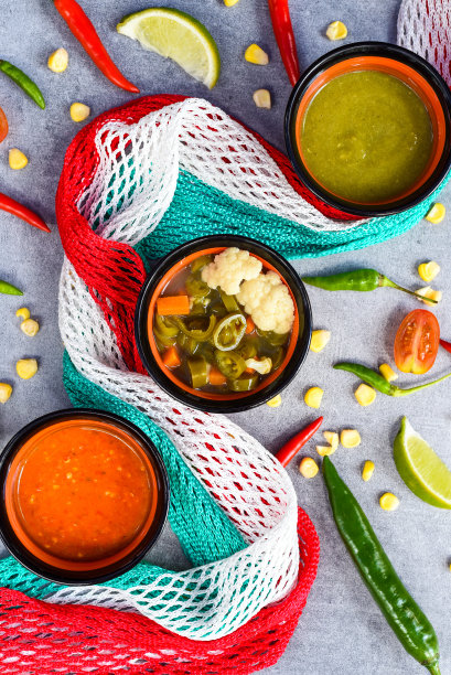 三种墨西哥酱汁放在木板上，灰色背景上有蔬菜图片下载