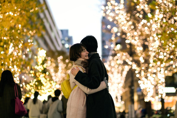 圣诞节，情侣在灯火通明的大街上相拥图片下载