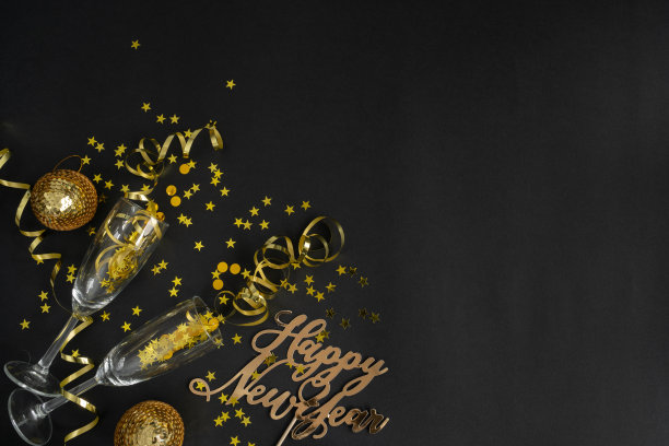 跨年构图，用香槟酒杯、金色装饰和复制空间。图片下载